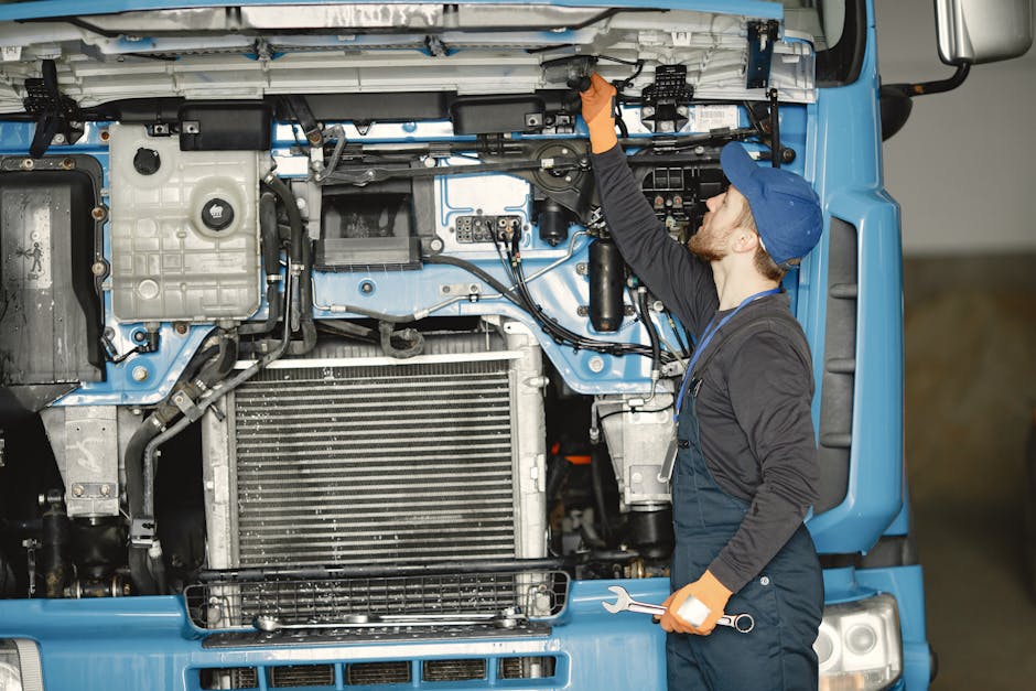 A mechanic working on a truck engine in a workshop, showcasing expertise in vehicle repair.